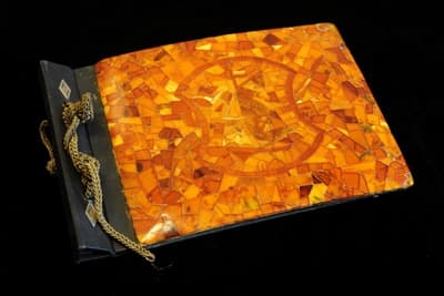 Oprawa albumu fotograficznego lub pamiętnika z okładziną zdobioną bursztynową mozaiką, Polska, 1 poł. XX w.; bursztyn, papier, mosiądz, srebro; wys. 16 cm, szer. 23 cm, gł. 2 cm